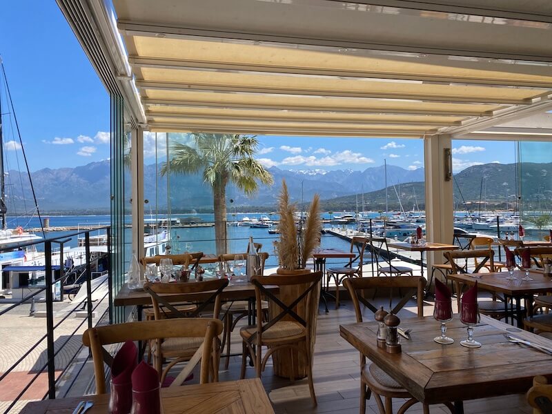 Terrazza sul porto con montagne della Corsica sullo sfondo