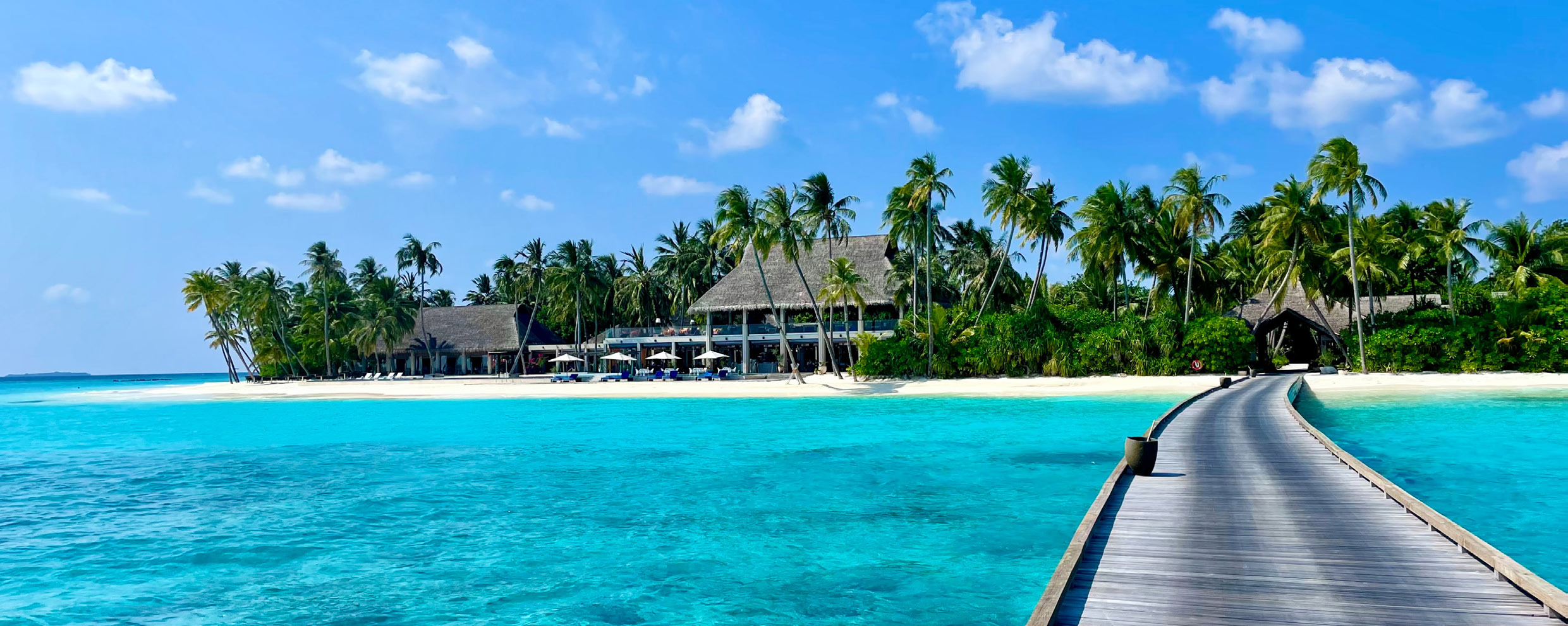 Resort tropicale delle Maldive raggiunto da una passerella sulla laguna turchese