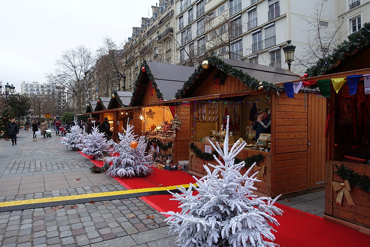 Bancarelle di Natale a Parigi con abeti bianchi, decorazioni e tappeto rosso davanti al municipio del 15° arrondissement