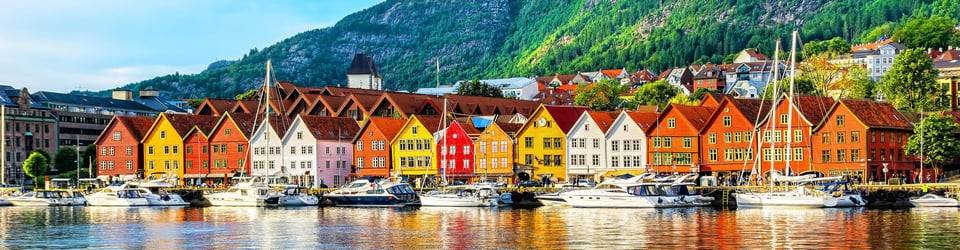 Le case colorate di Bryggen a Bergen, davanti al porto e alle colline verdi