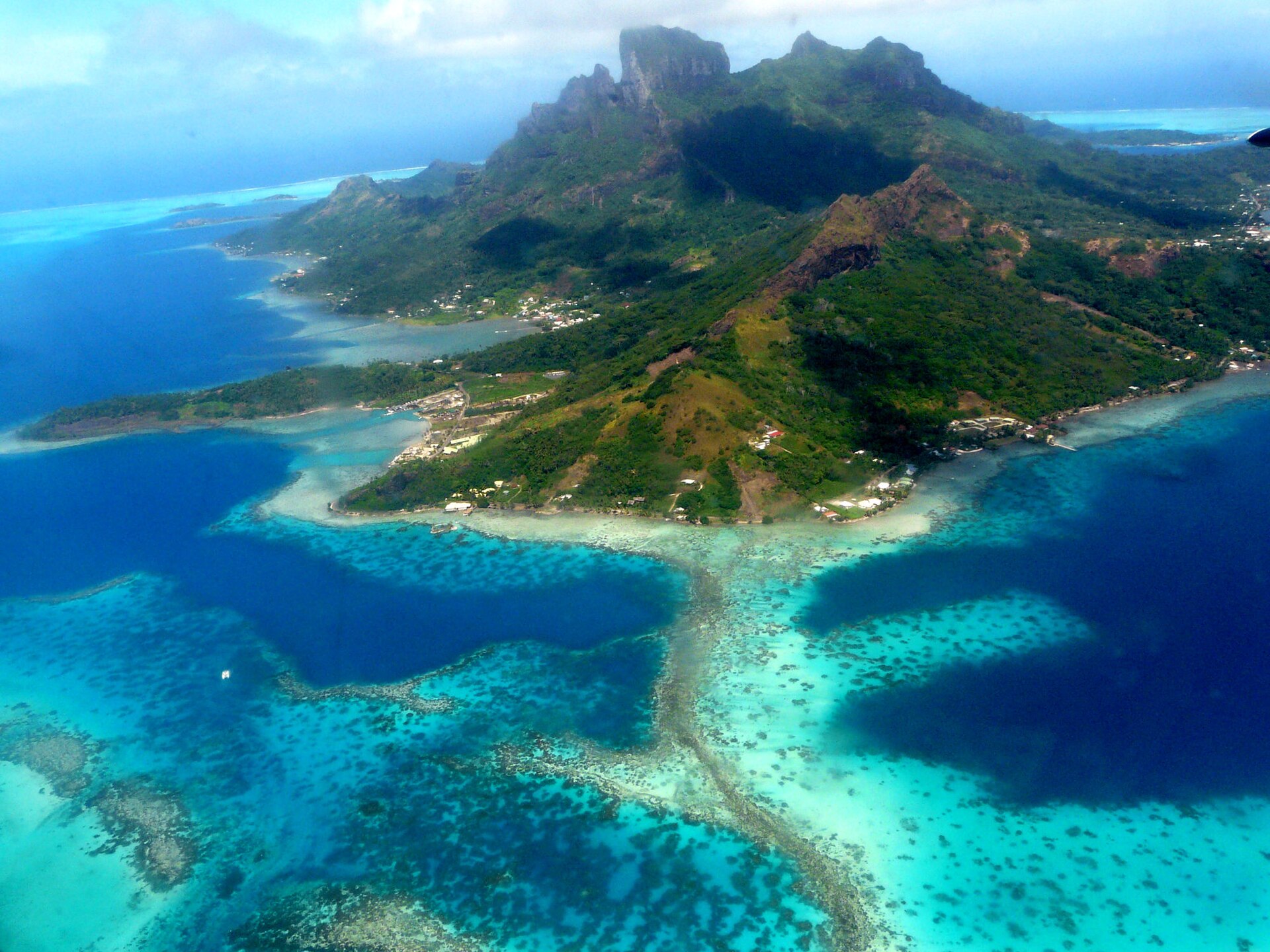 Veduta aerea di Bora Bora, tra le acque turchesi della laguna e le montagne vulcaniche.
