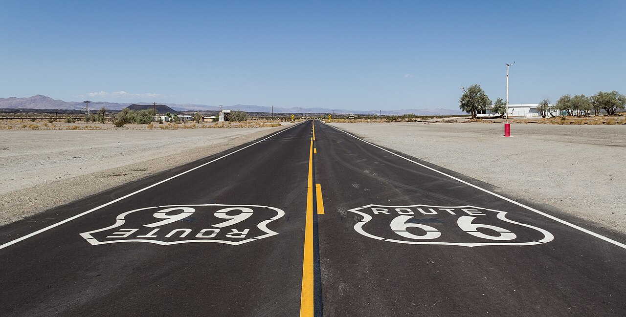La Route 66 ad Amboy, con il simbolo dipinto sulla strada, il deserto e il cielo azzurro